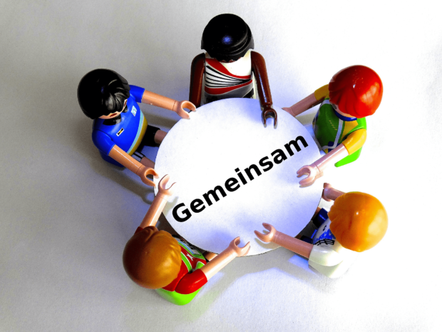 schuldenregulierung gemeinsam bewältigen, figuren am tisch